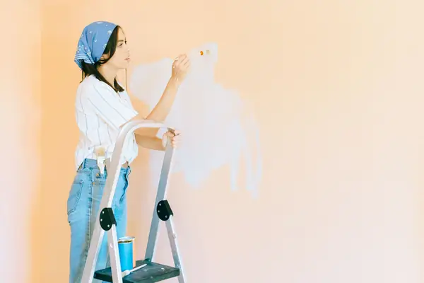 Interior painting in Fremont: painter on a stepladder rolling a wall